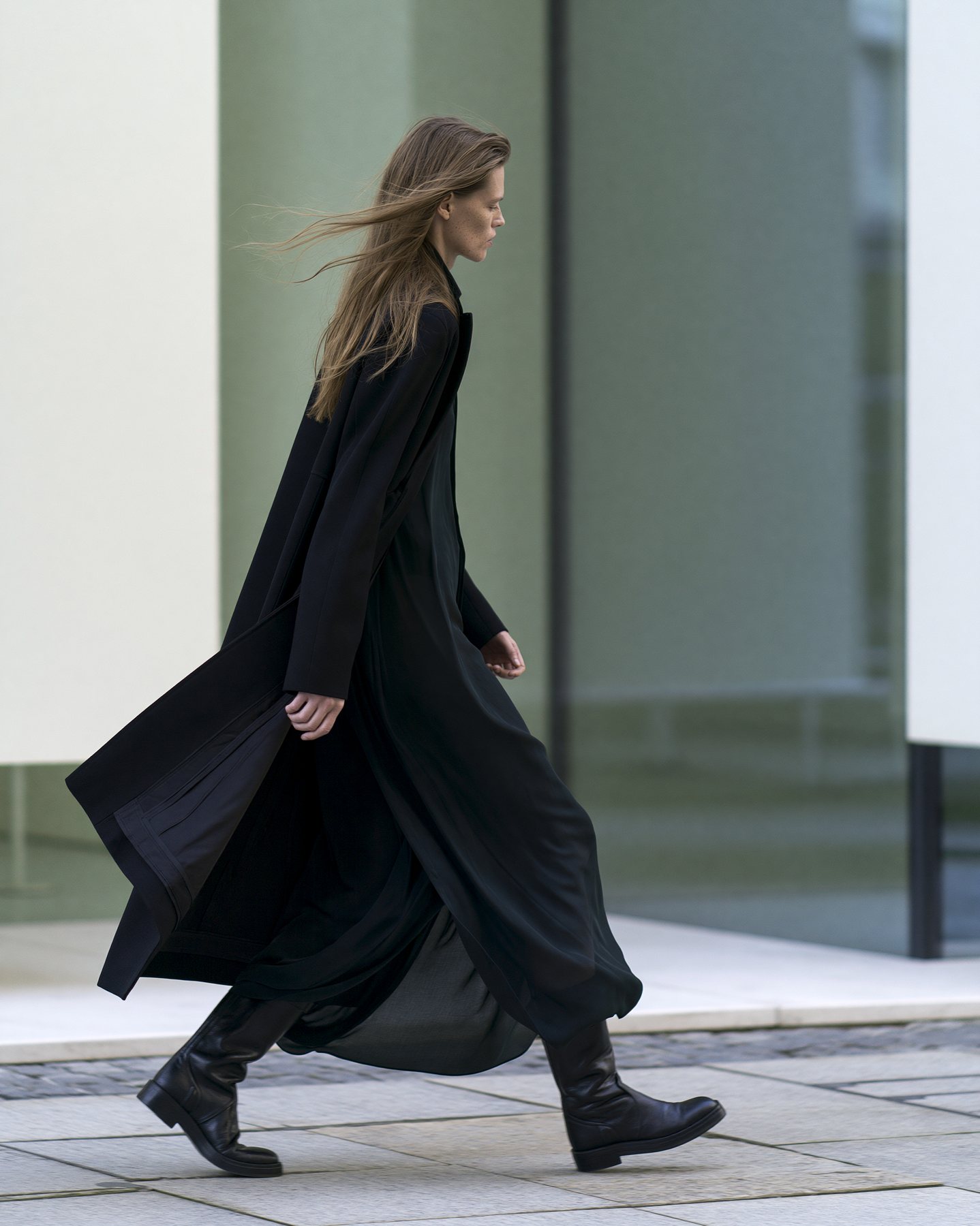 Side-view full-body fashion editorial in flowing black layers.