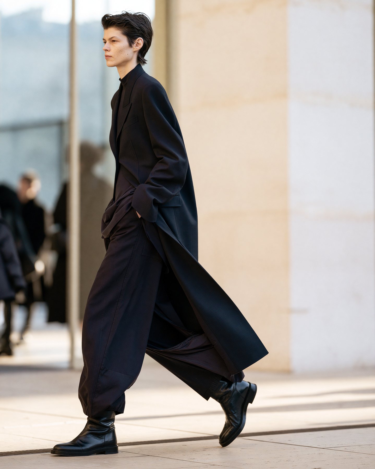 Side-view full-body street fashion look in dark layers and clean city light.