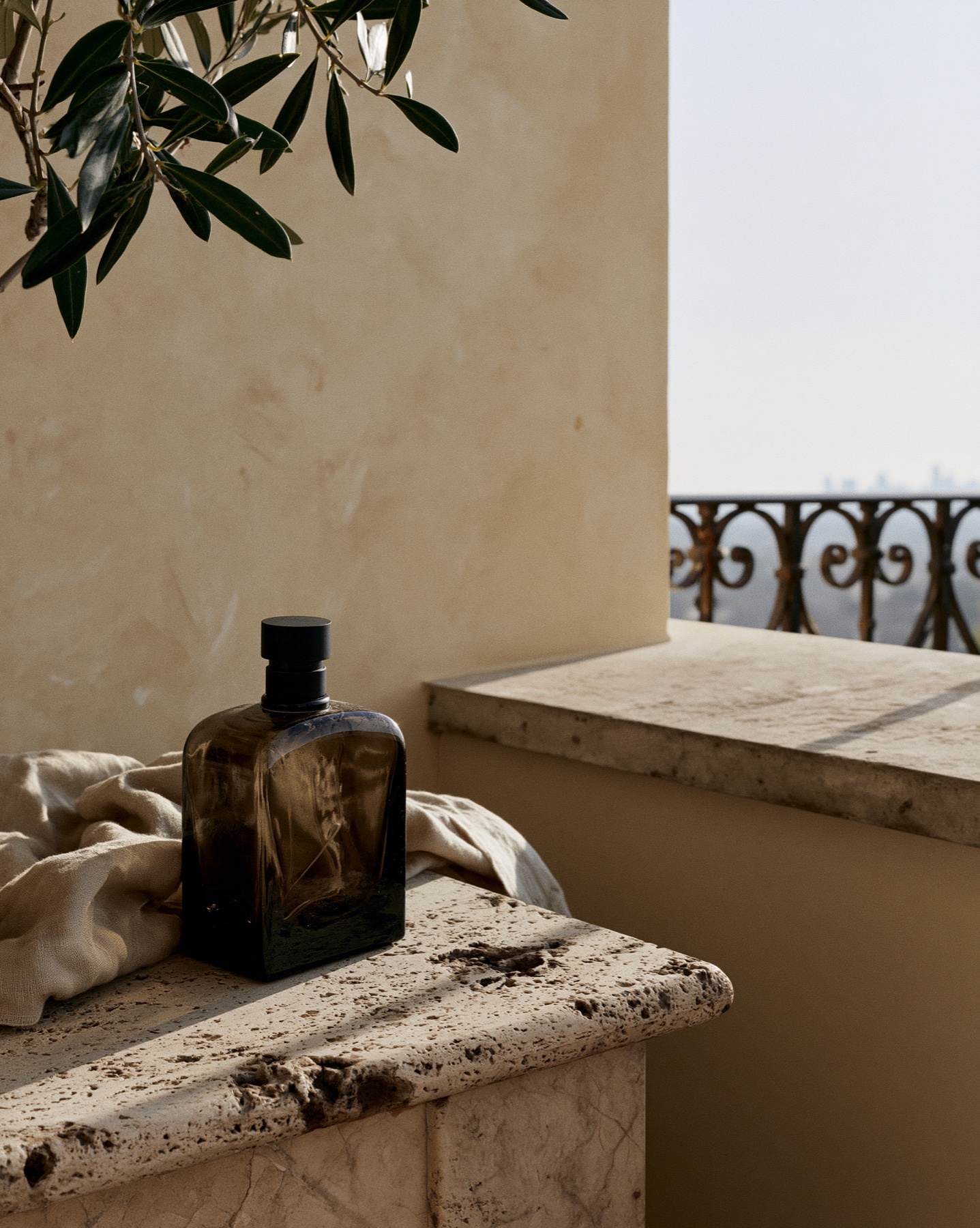 Dark fragrance bottle on travertine beside the sea.