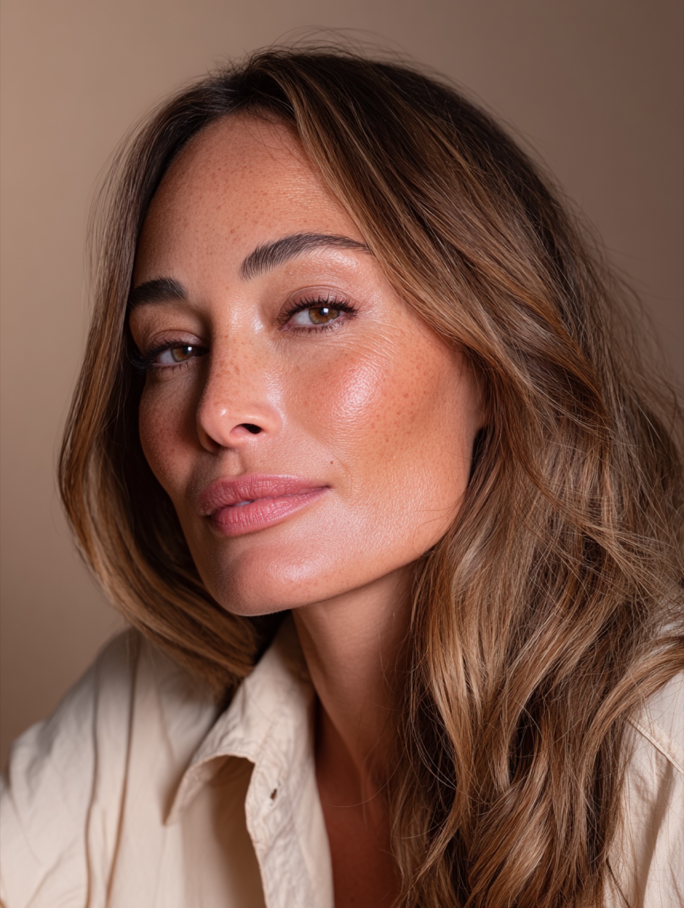 Realistic mature AI beauty portrait in warm studio light.