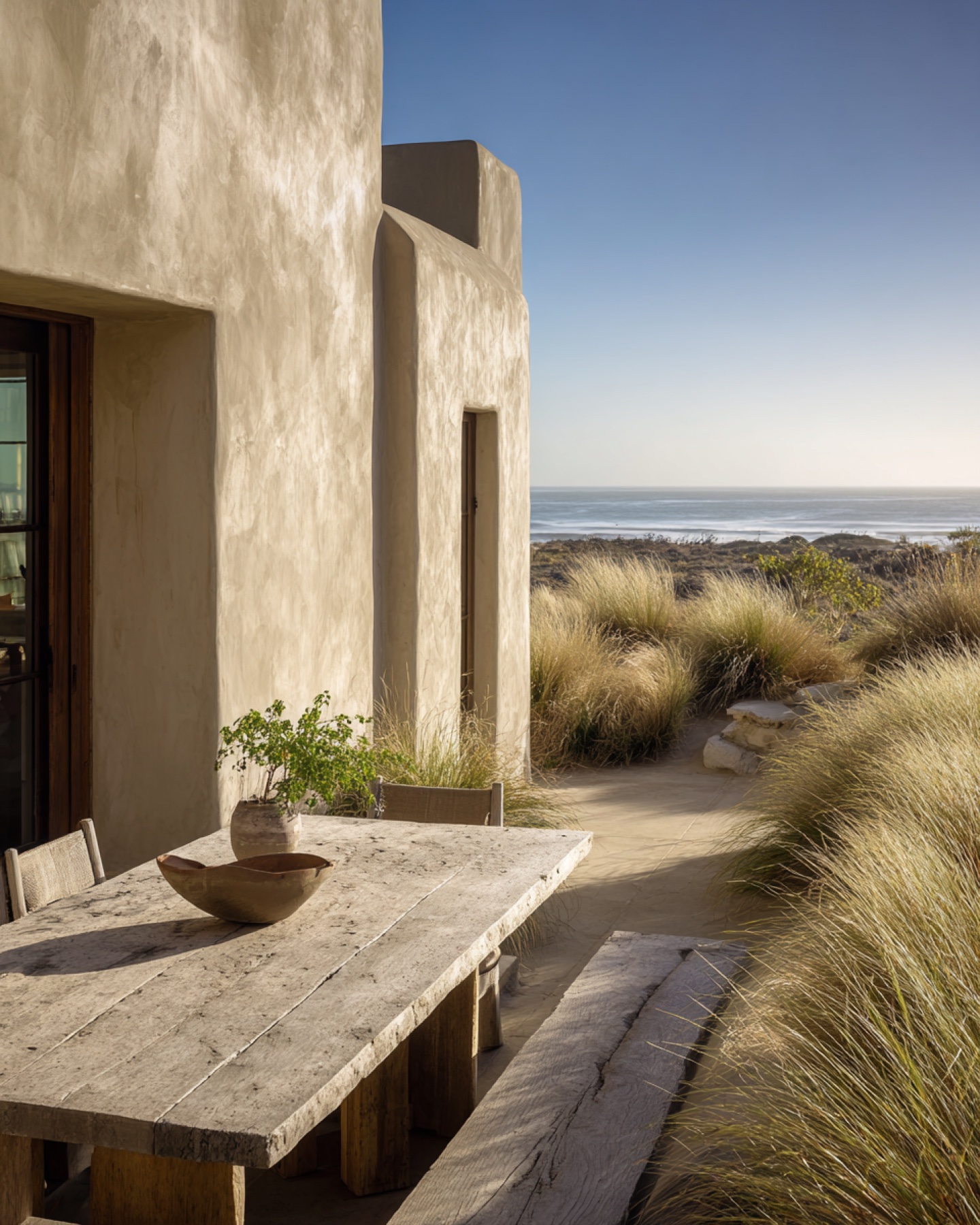 Minimal coastal house terrace surrounded by natural grasses.