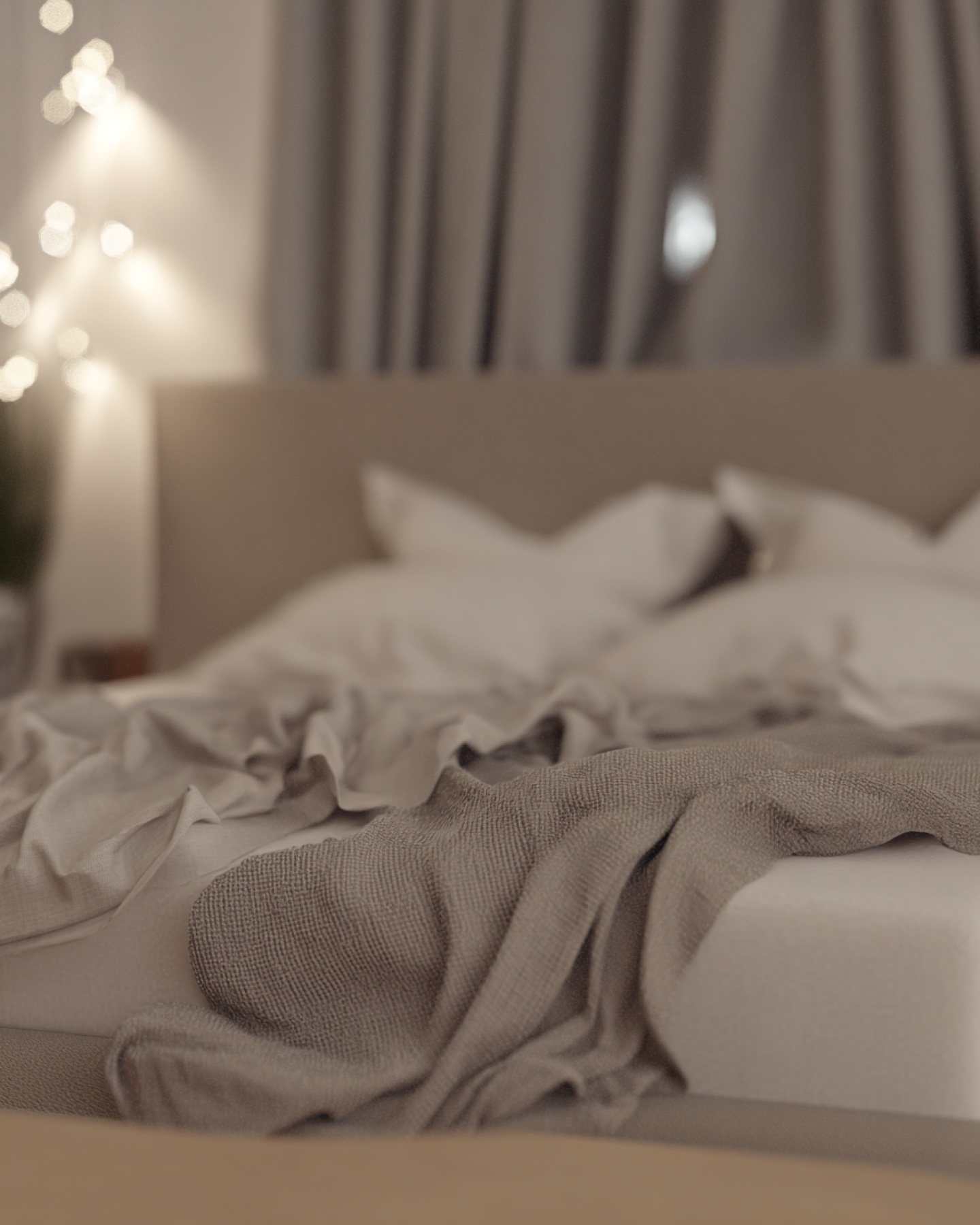Softly focused neutral bedroom with layered linen and evening lights.